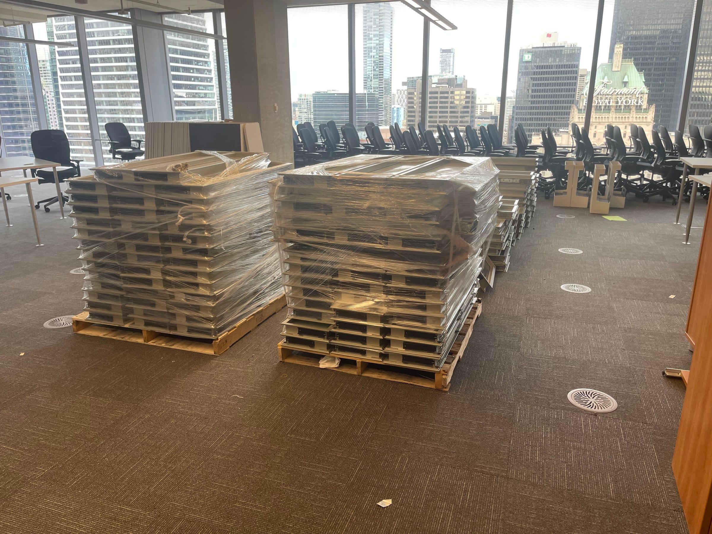 An office move: furniture wrapped and stacked on skids in a downtown Toronto office